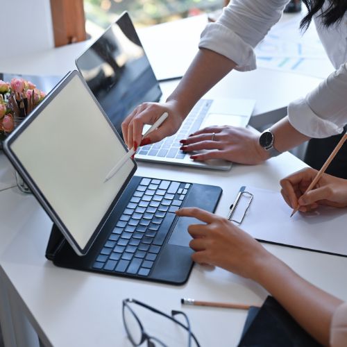 Tablet mit Tastatur und zwei Personen die sich beraten